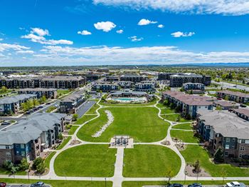 An aerial view of a city park with houses and green grass